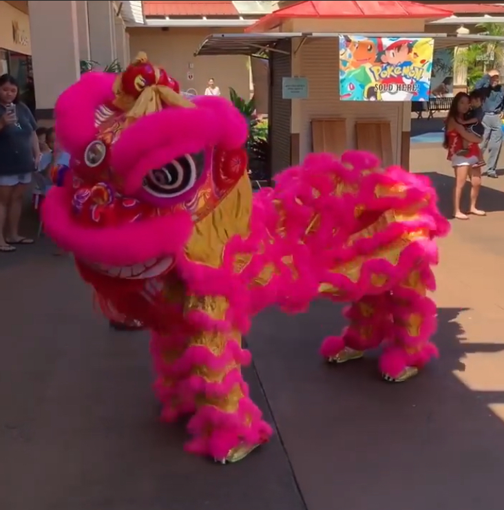 A large, pink dragon stands at a display in Kauai for a Chinese New Year celebration