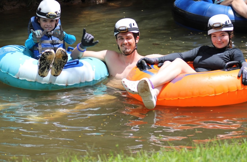 three people tubing a river in Hawaii