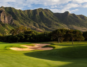 the fairway at a kauai golf course with a bunker and mountains in the background