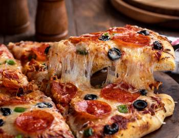 a slide of pizza pulled from full pie at Kōloa Pizza Kitchen and Bar in poipu